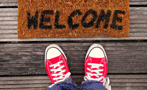 red Keds in front of a welcome mat