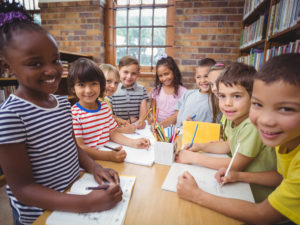 Photo kids smiling at desk